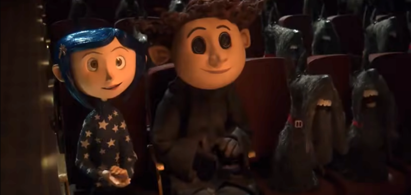 Coraline, Other Wybie, and numerous scottie dogs sit in theater seats in a scene from Coraline